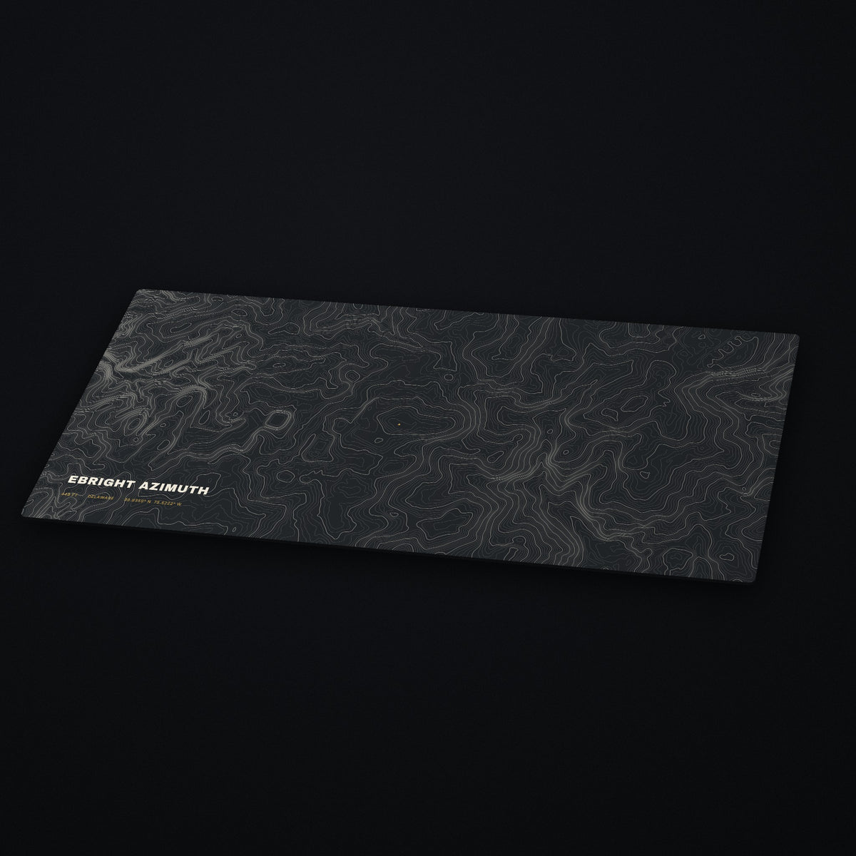 Ebright Azimuth Topo Desk Mat at an angle on a dark desk