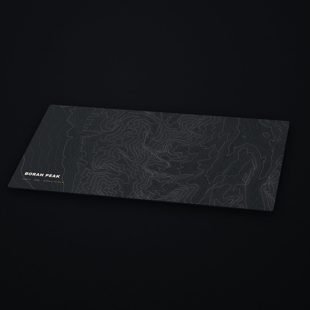 Borah Peak Topo Desk Mat at an angle on a dark desk