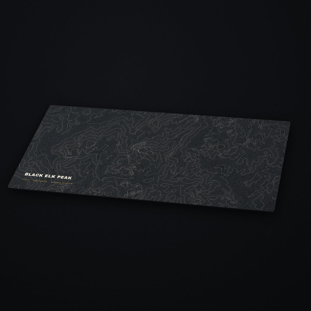Black Elk Peak Topo Desk Mat at an angle on a dark desk
