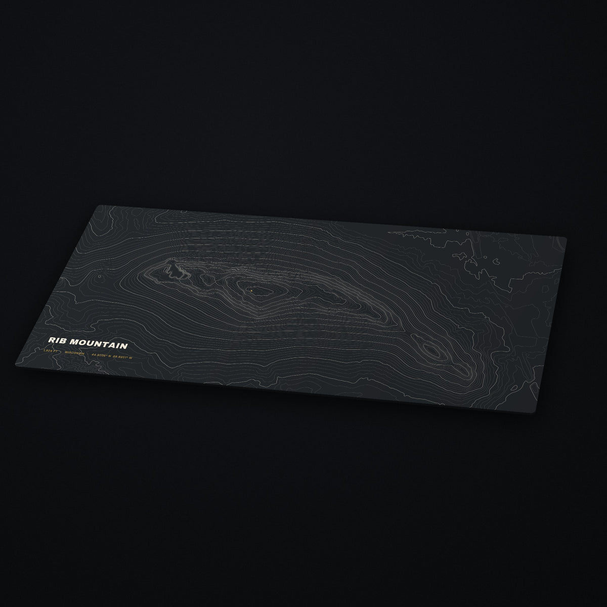Rib Mountain Topo Desk Mat at an angle on a dark desk