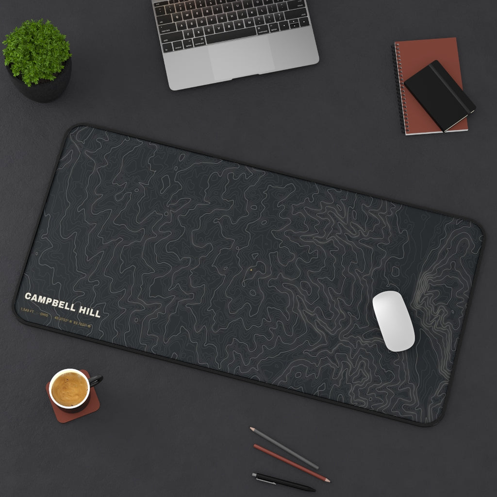 Campbell Hill Topo desk mat on a desk with a laptop, mouse and coffee cup for scale