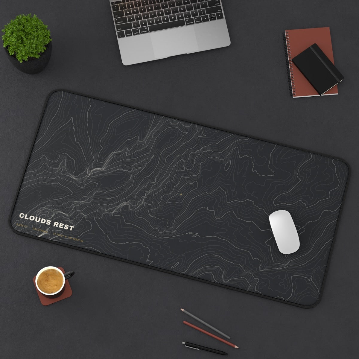 Clouds Rest Topo desk mat on a desk with a laptop, mouse and coffee cup for scale