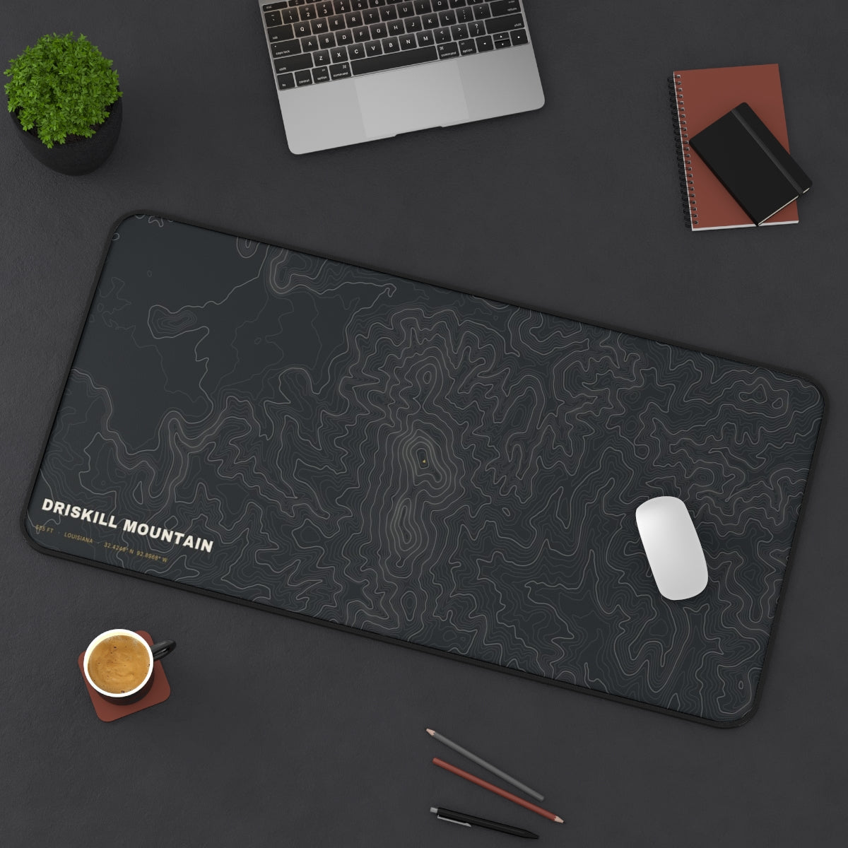 Driskill Mountain Topo desk mat on a desk with a laptop, mouse and coffee cup for scale