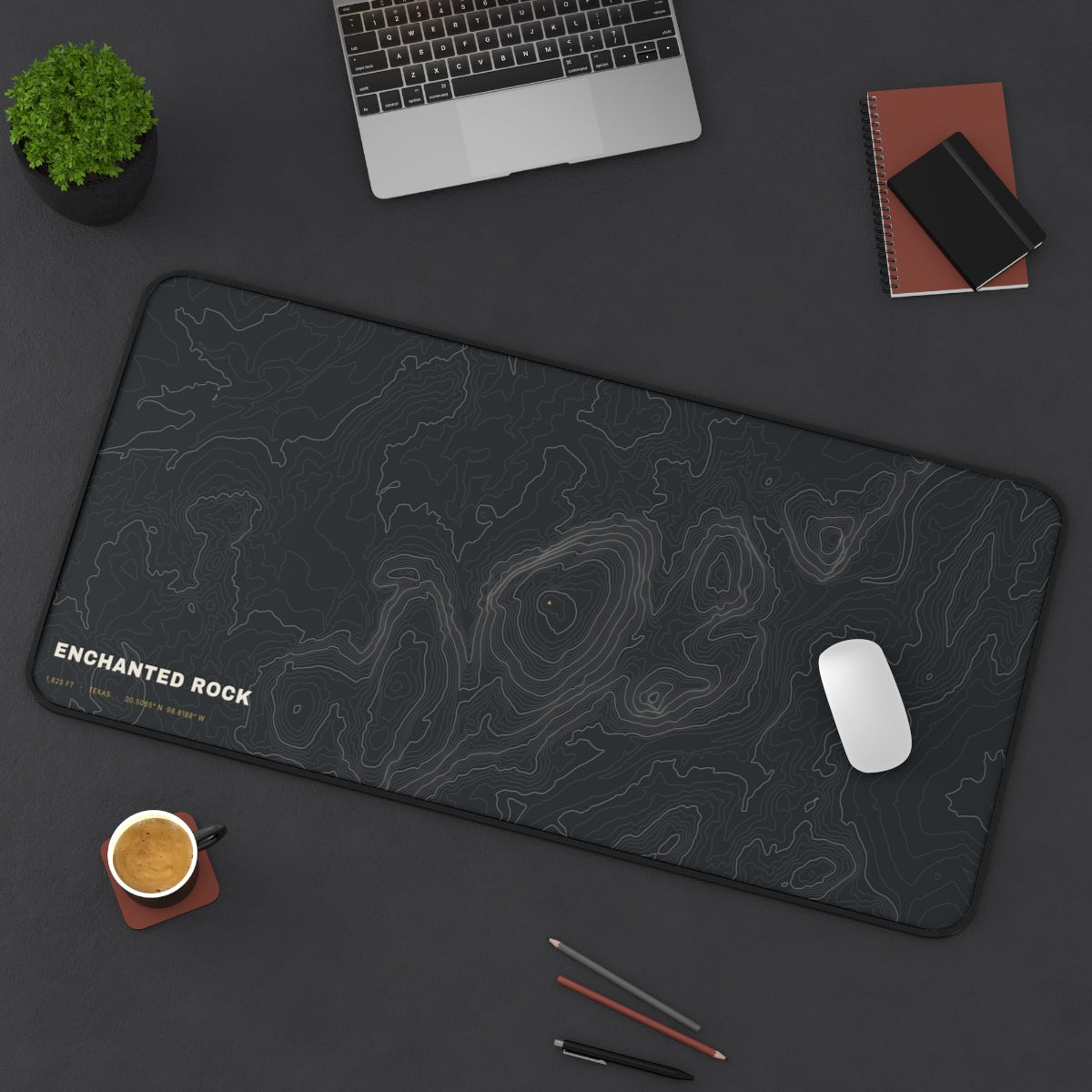 Enchanted Rock Topo desk mat on a desk with a laptop, mouse and coffee cup for scale