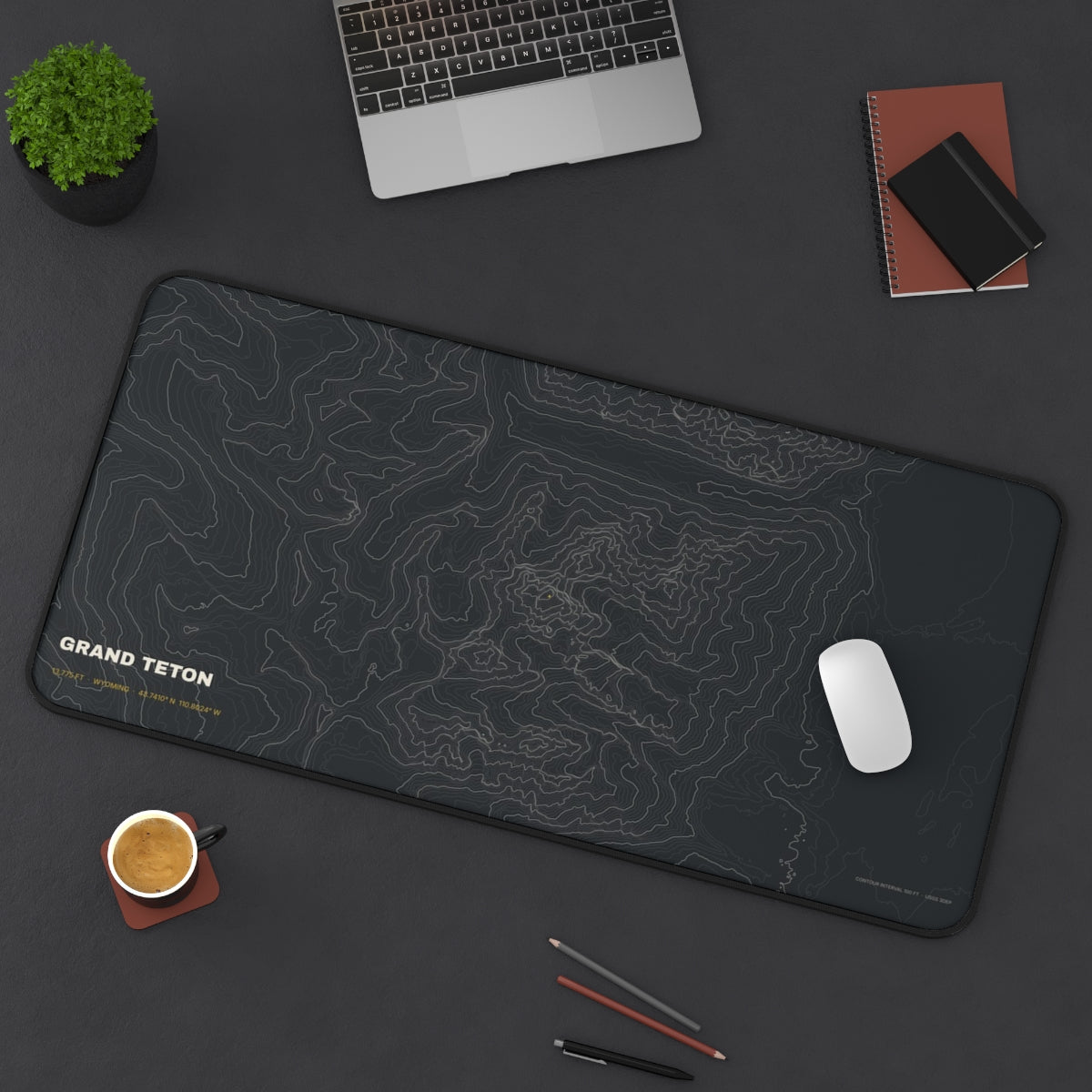 Grand Teton Topo desk mat on a desk with a laptop, mouse and coffee cup for scale