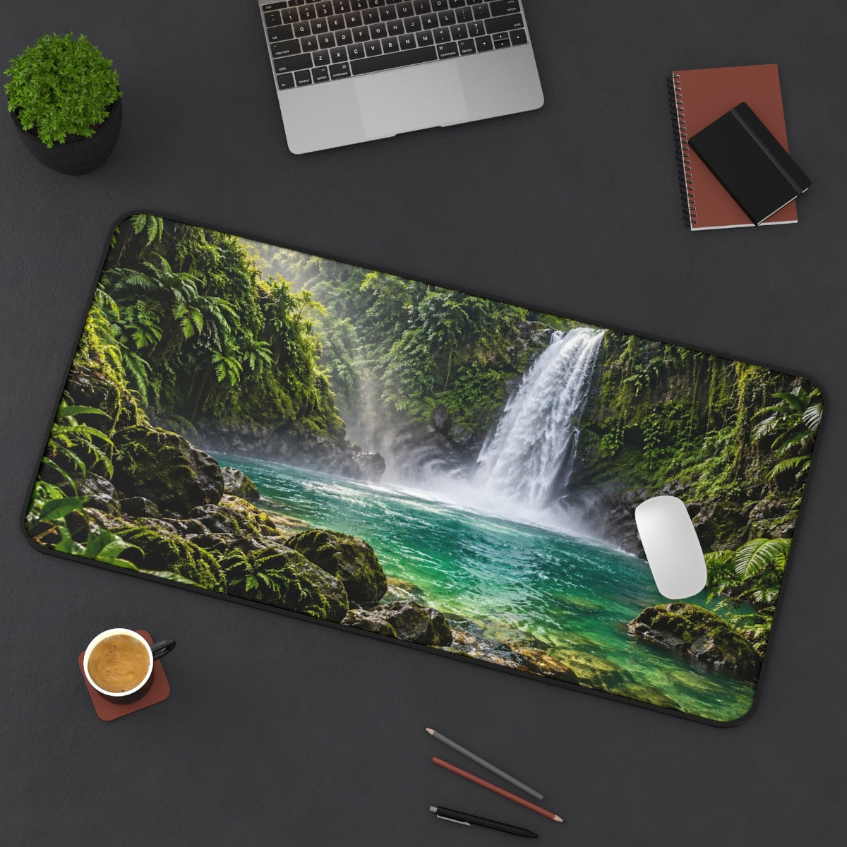 Jungle Falls desk mat on a desk with a laptop, mouse and coffee cup for scale
