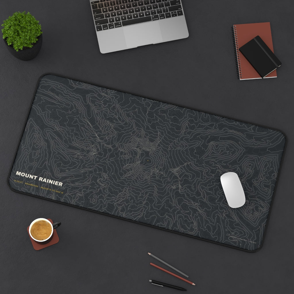 Mount Rainier Topo desk mat on a desk with a laptop, mouse and coffee cup for scale