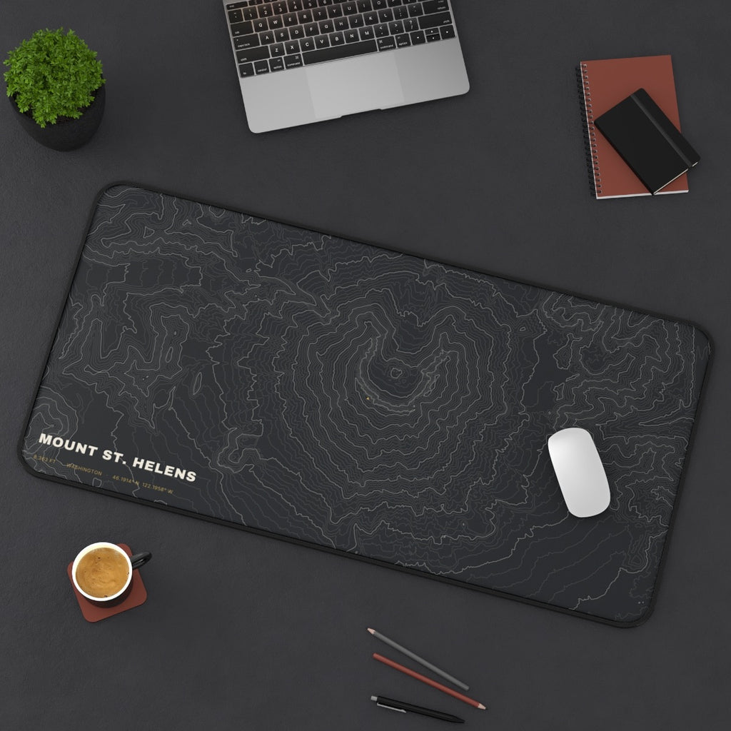 Mount St. Helens Topo desk mat on a desk with a laptop, mouse and coffee cup for scale