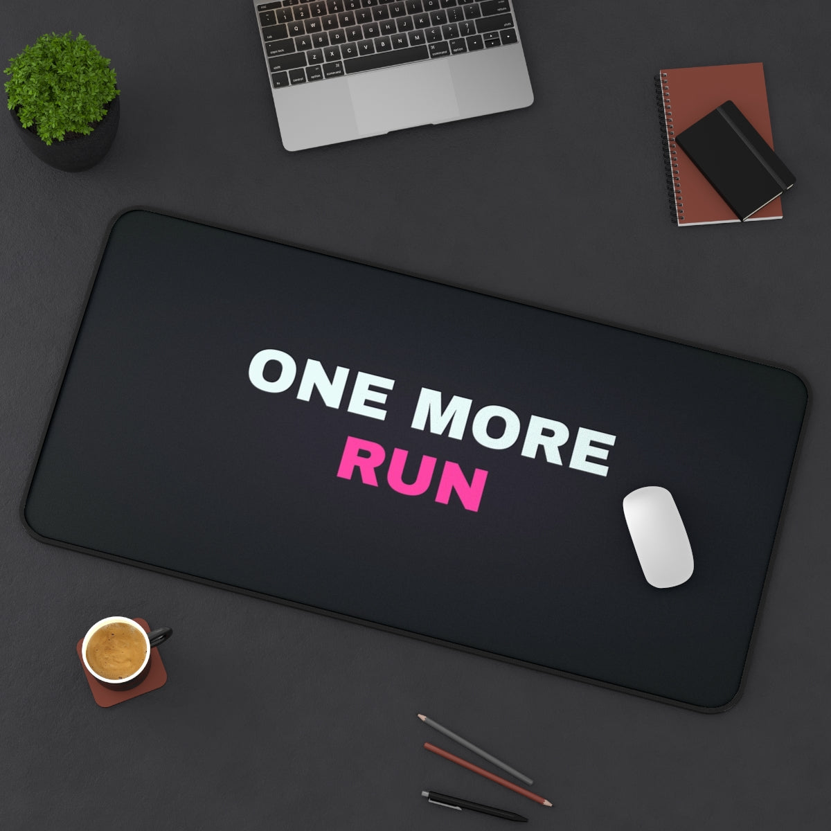 One More Run desk mat on a desk with a laptop, mouse and coffee cup for scale