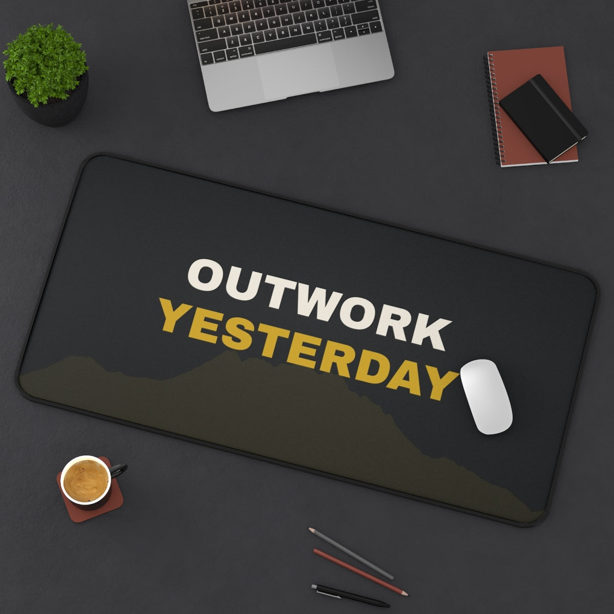 Outwork Yesterday desk mat on a desk with a laptop, mouse and coffee cup for scale