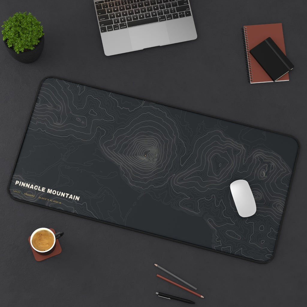 Pinnacle Mountain Topo desk mat on a desk with a laptop, mouse and coffee cup for scale