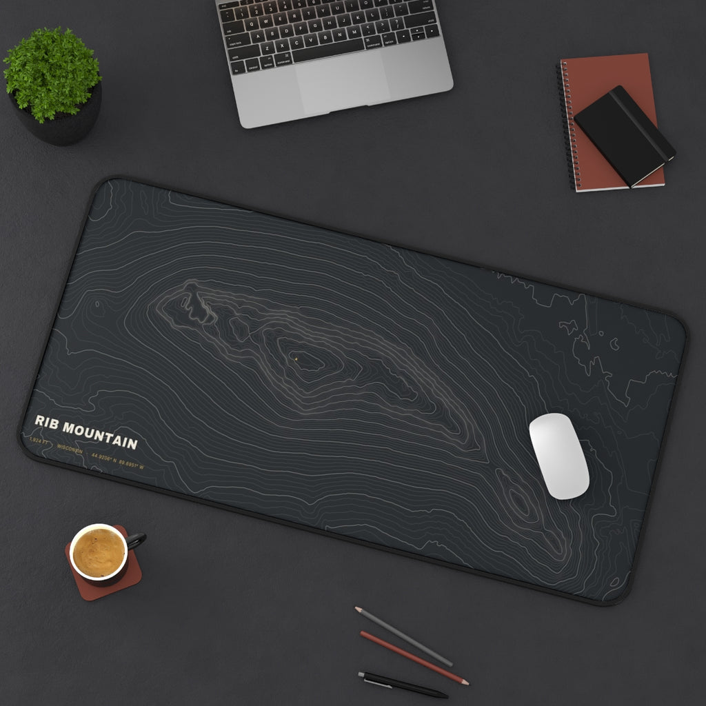 Rib Mountain Topo desk mat on a desk with a laptop, mouse and coffee cup for scale