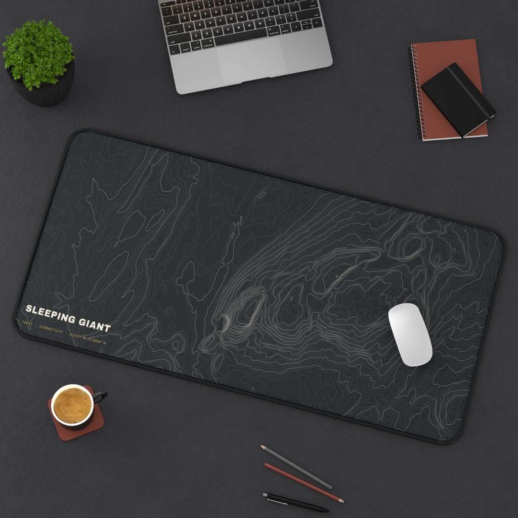 Sleeping Giant Topo desk mat on a desk with a laptop, mouse and coffee cup for scale